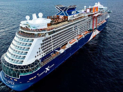 Large cruise ship with blue hull and white superstructure in ocean waters