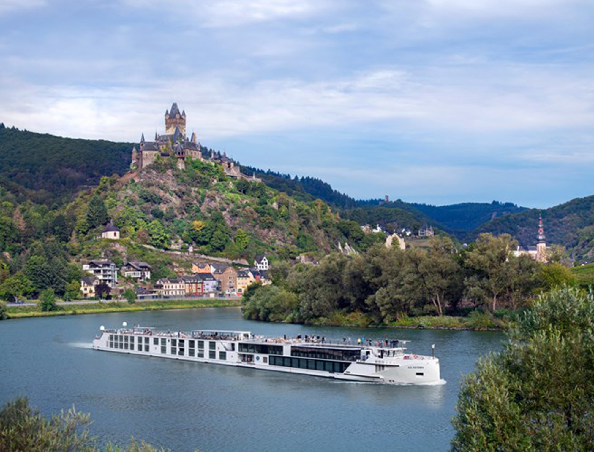 10188_50034_resize_0_500 A modern river cruise ship navigates the Moselle River with Reichsburg Castle on the hilltop above Cochem, Germany