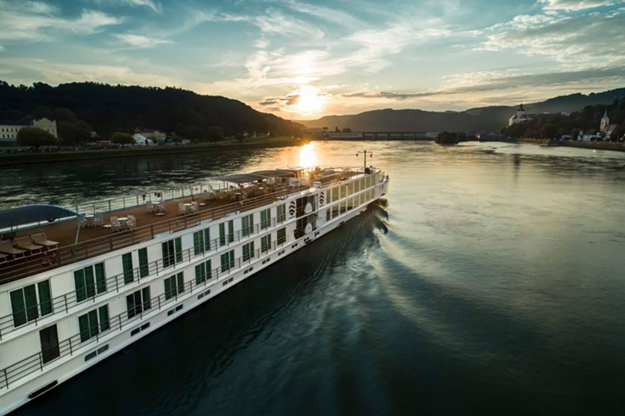 2224_50034_resize_0_500 Uniworld river cruise ship at sunset navigating a scenic alpine river valley