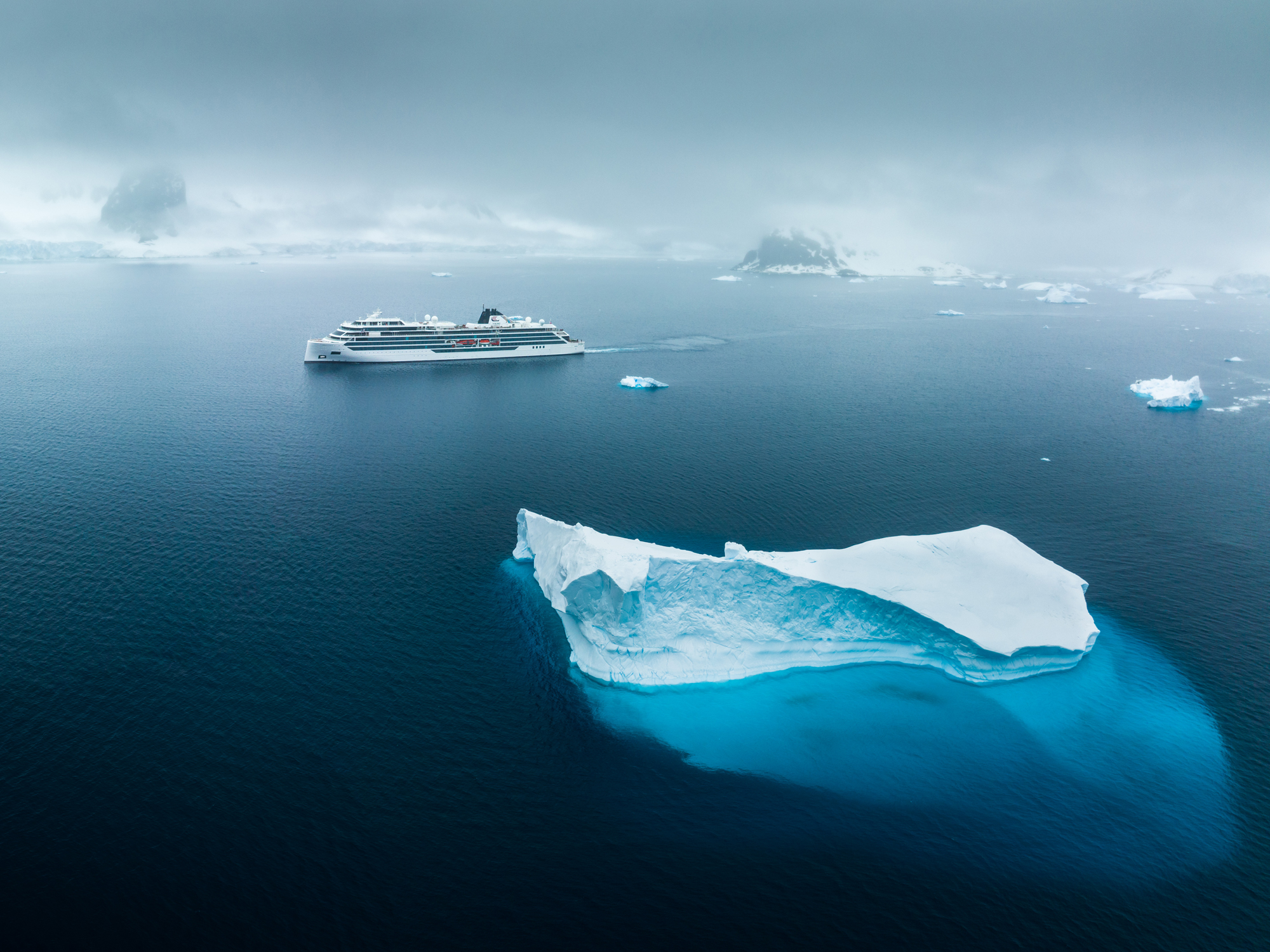 Viking Ocean cruise ship sailing through icy polar waters near large icebergs