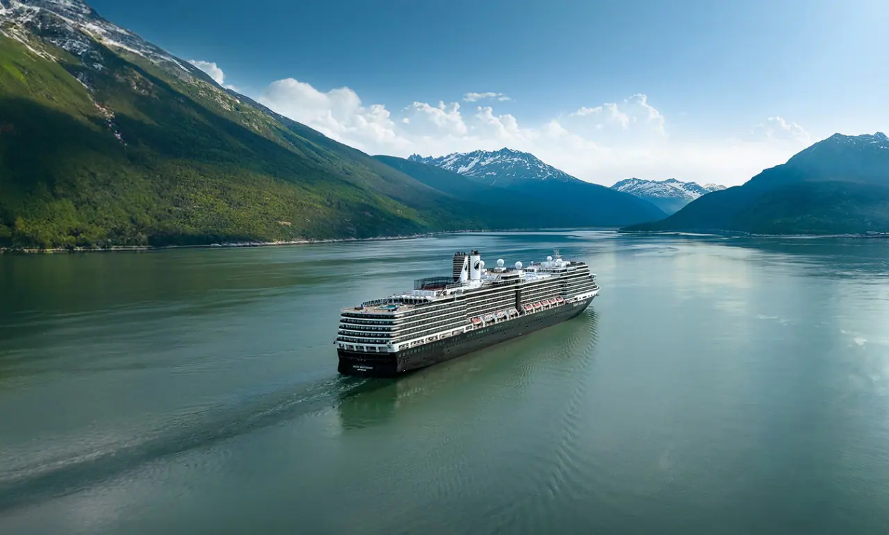 Cruise Ship in Alaskan Mountain Fjord A large cruise ship sailing through a serene fjord surrounded by lush green mountains