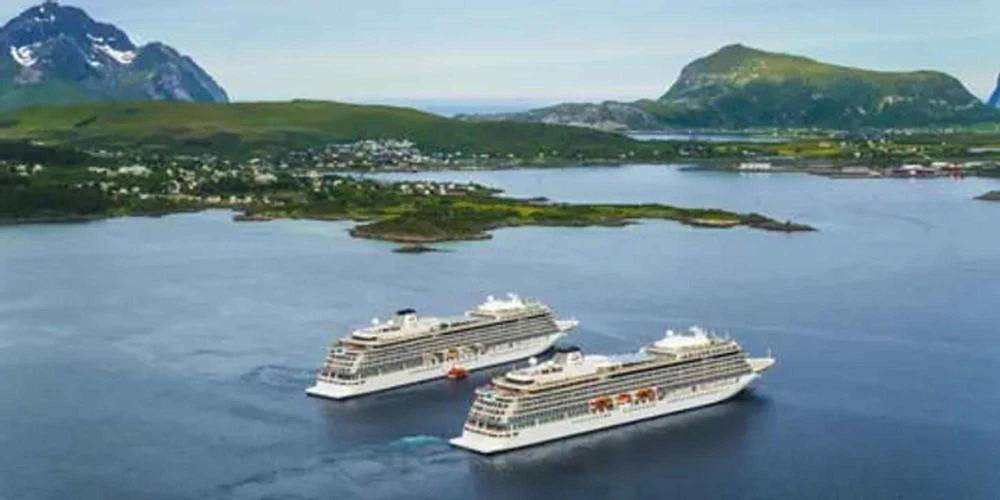 Two cruise ships anchored in a picturesque Norwegian fjord surrounded by lush green mountains