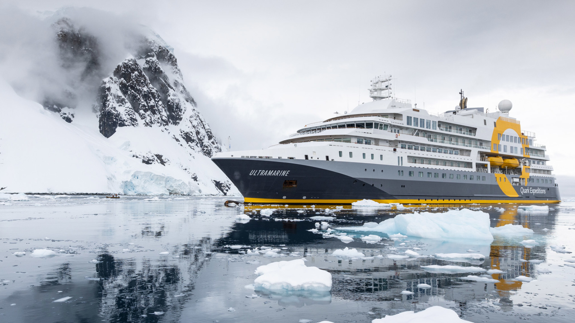 Hero_Sam-Crimmin-V3-3702 Ultramarine expedition cruise ship in Antarctic waters surrounded by snow-capped mountains and icebergs