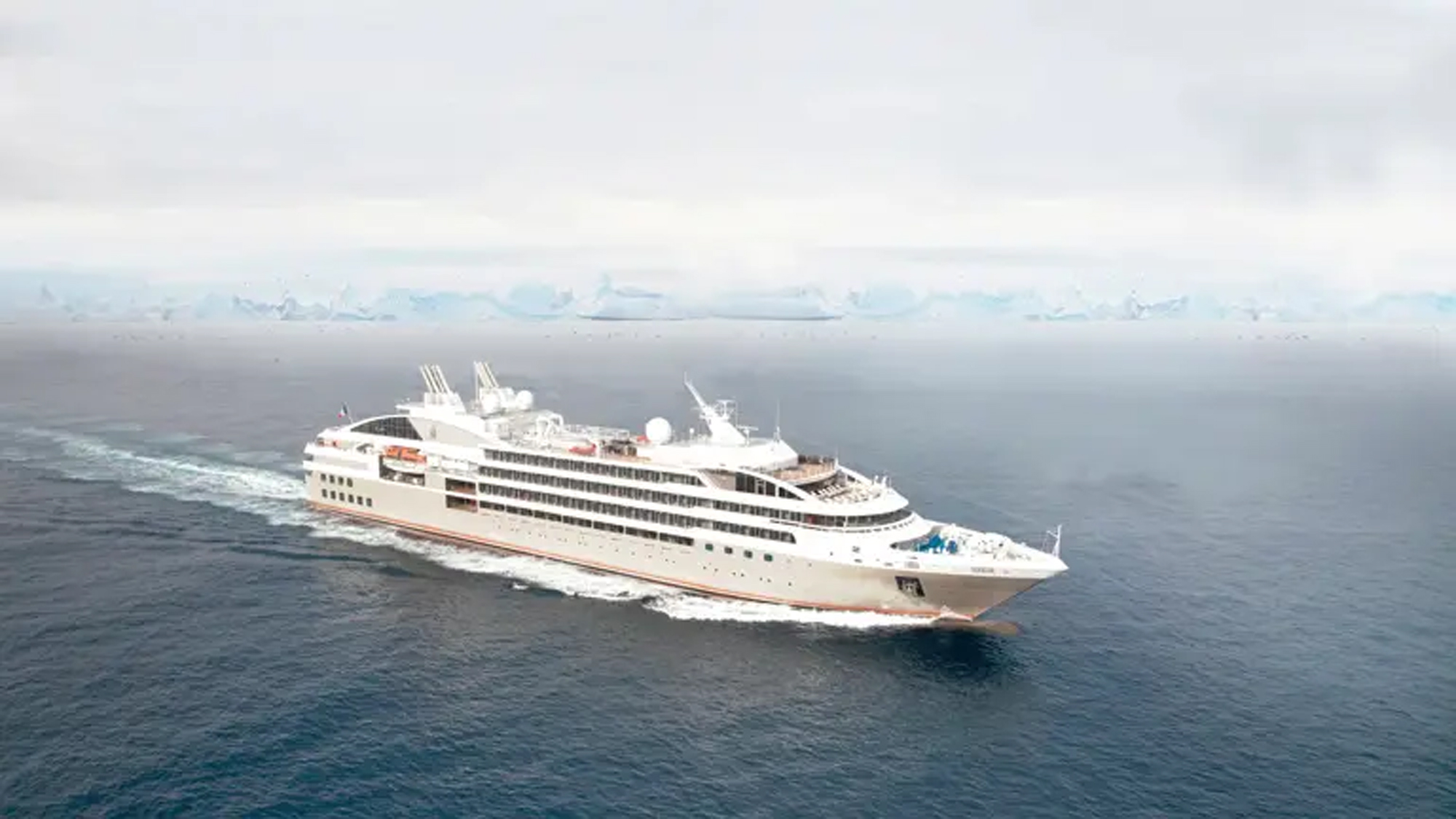 Luxury Expedition Cruise Ship in Polar Regions A sleek white expedition cruise ship navigating through cold, misty waters with an icy horizon