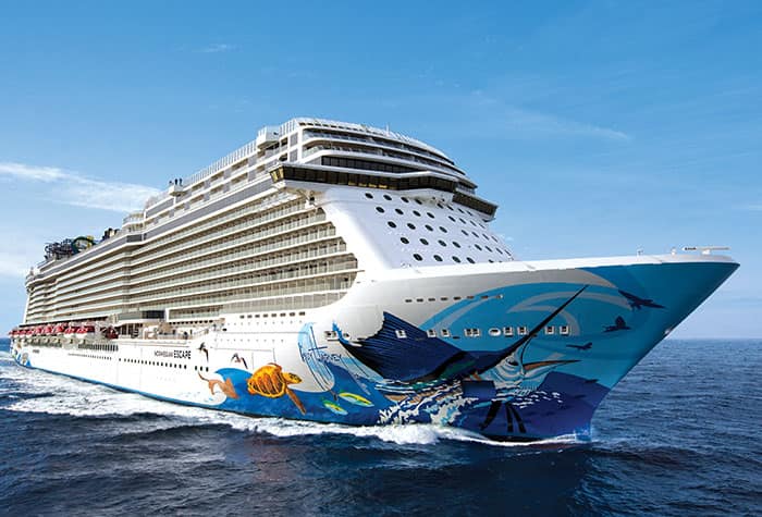 Norwegian Cruise Line Ocean Vessel at Sea A large, modern cruise ship with vibrant marine-themed hull artwork sailing on blue ocean waters
