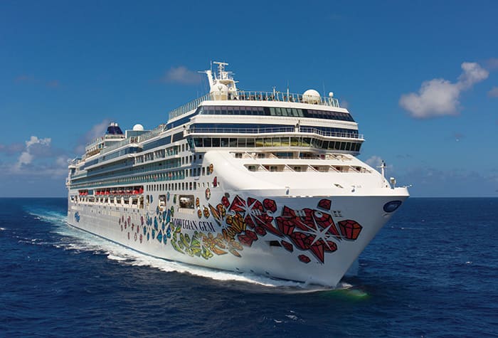 Norwegian Gem Cruising Blue Waters Norwegian Cruise Line ship sailing across bright blue ocean