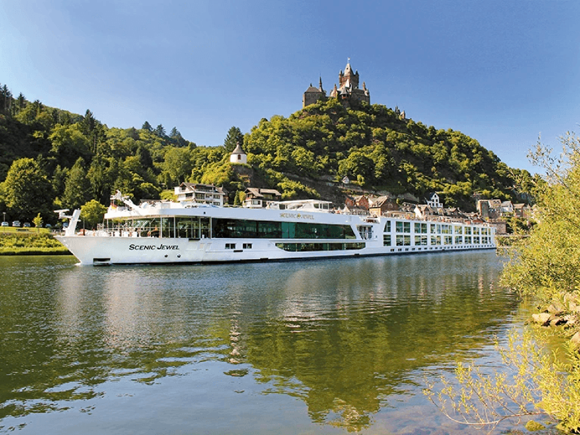 Scenic Jewel river cruise ship sailing past a hilltop castle on the Danube