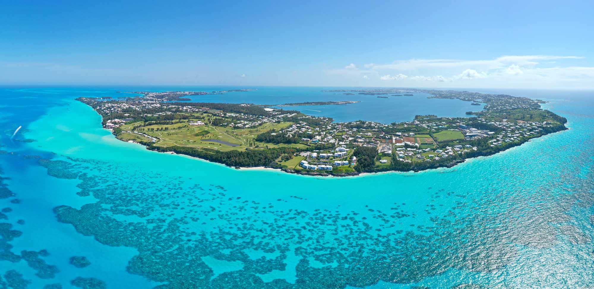 Aerial View of Bermuda Island An aerial photograph of Bermuda island surrounded by stunning turquoise Atlantic Ocean waters, showcasing the island's lush green vegetation, residential areas, and pristine beaches.
