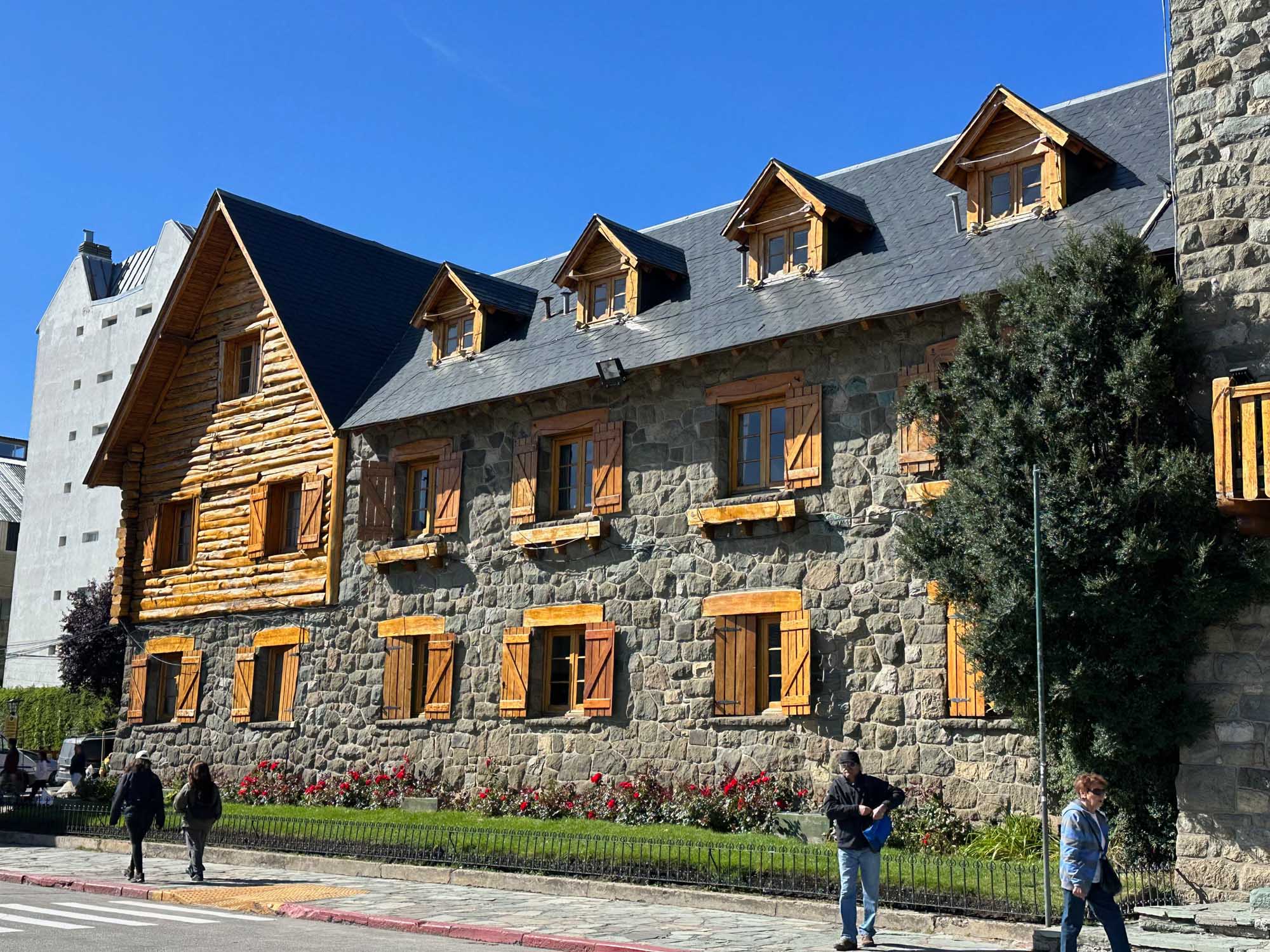 Historic Stone Building with Mansard Roof A striking heritage stone building featuring a mansard roof with dormer windows, golden wooden