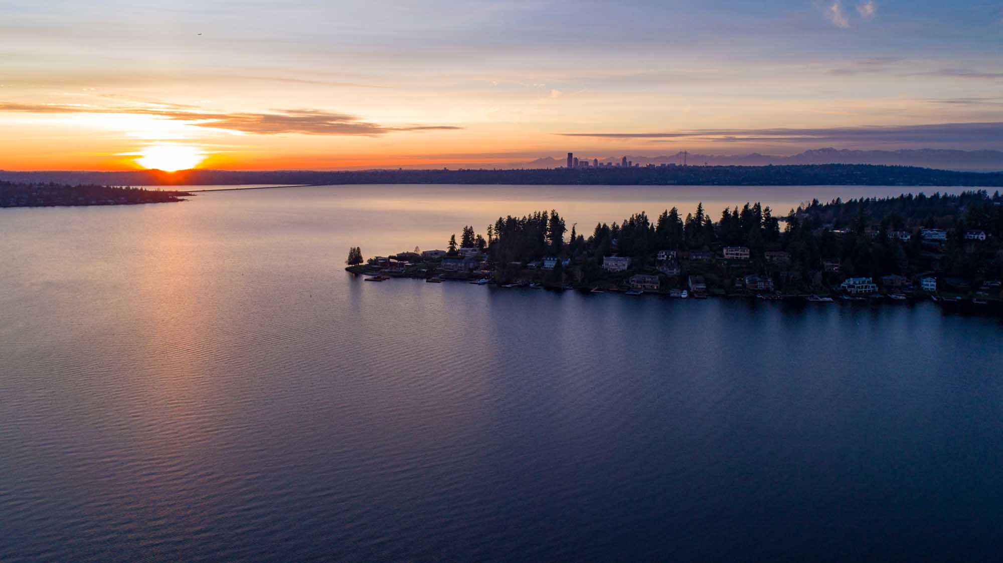 Lake Washington Sunset with Seattle Skyline A breathtaking sunset view over Lake Washington, featuring a residential waterfront community
