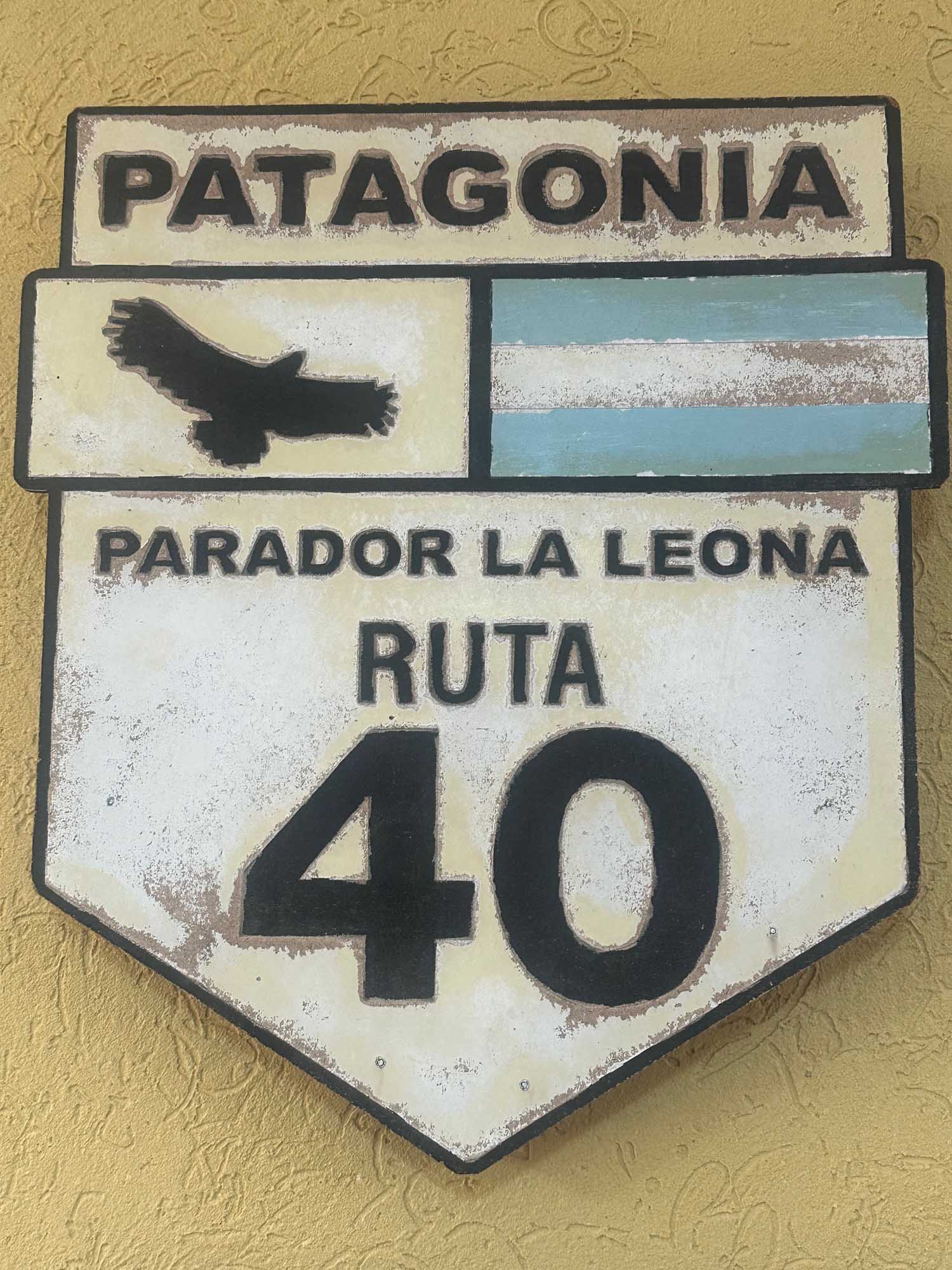 Patagonia Route 40 Directional Sign A weathered vintage-style road sign for Patagonia's Route 40 (Ruta 40), featuring the text 'PARADOR