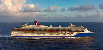 A large modern cruise ship from Carnival Cruise Lines sails through open ocean waters under