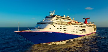 A large cruise ship operated by Carnival Cruise Lines sailing on open ocean waters under clear blue