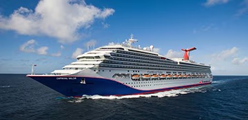 A large modern cruise ship with distinctive blue hull and red funnel stack cruising through calm