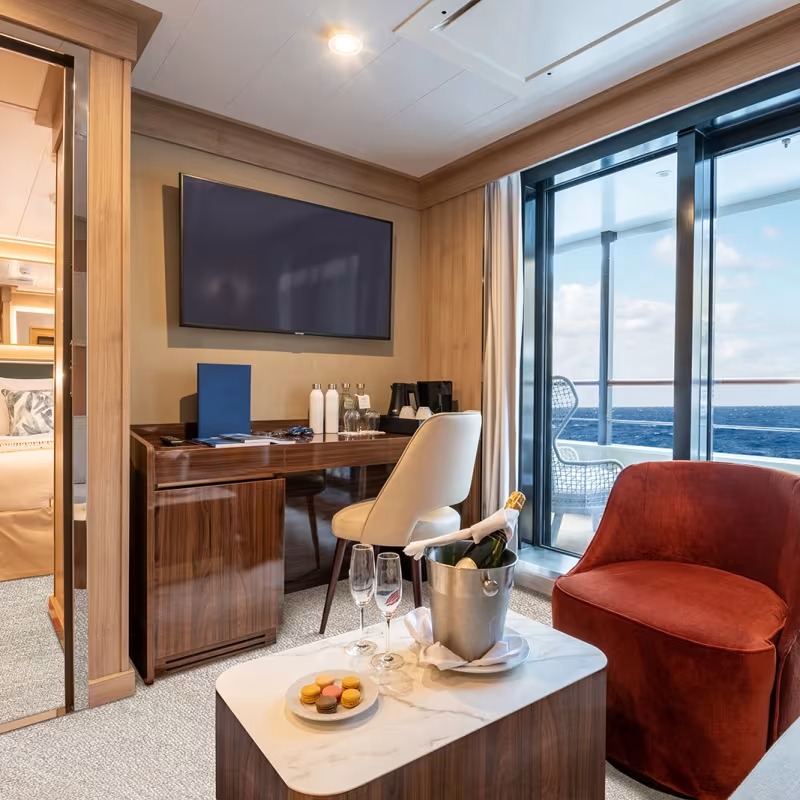 Quark Expeditions Suite with Ocean View A luxurious superior suite aboard a Quark Expeditions vessel featuring floor-to-ceiling windows