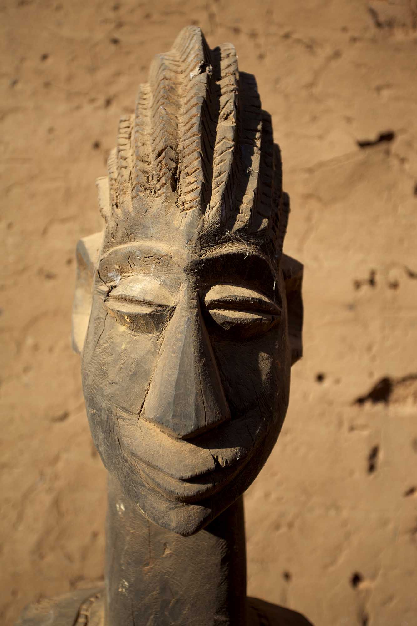 A carved wooden mask from the Dogon people of Mali, featuring distinctive geometric patterns
