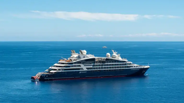 No-679_EG300424_Lipari_Sicile_Italie_-PONANT-Olivier_BLAUD Ponant cruise ship sailing in turquoise waters with sea lions swimming nearby