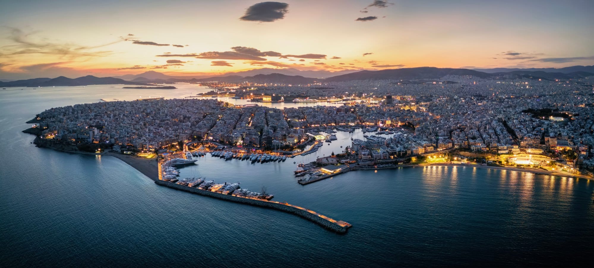 An aerial twilight view of Piraeus, Greece's largest port city near Athens, showcasing densely