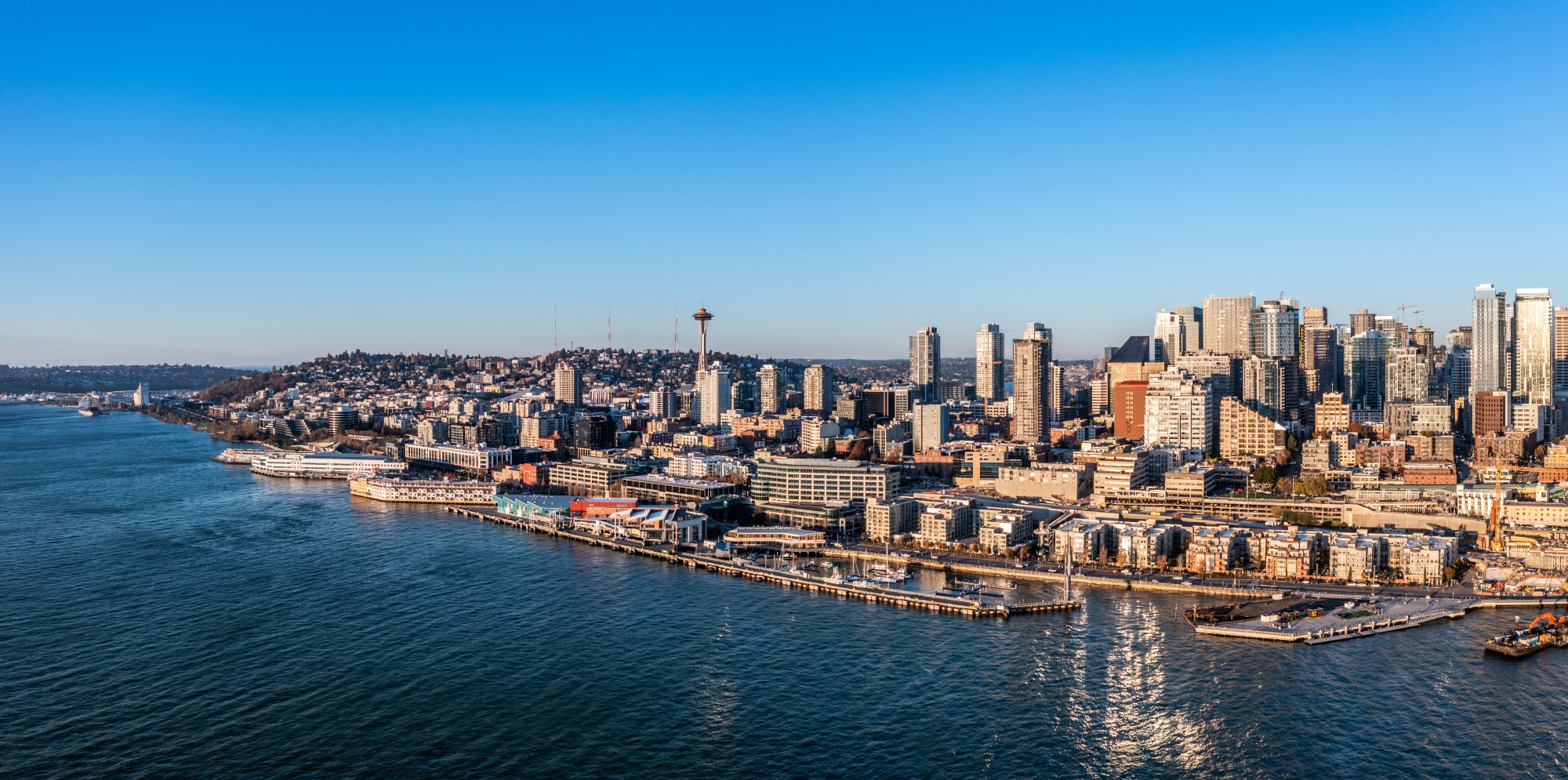 An aerial photograph of Seattle's downtown skyline and waterfront, featuring the iconic Space