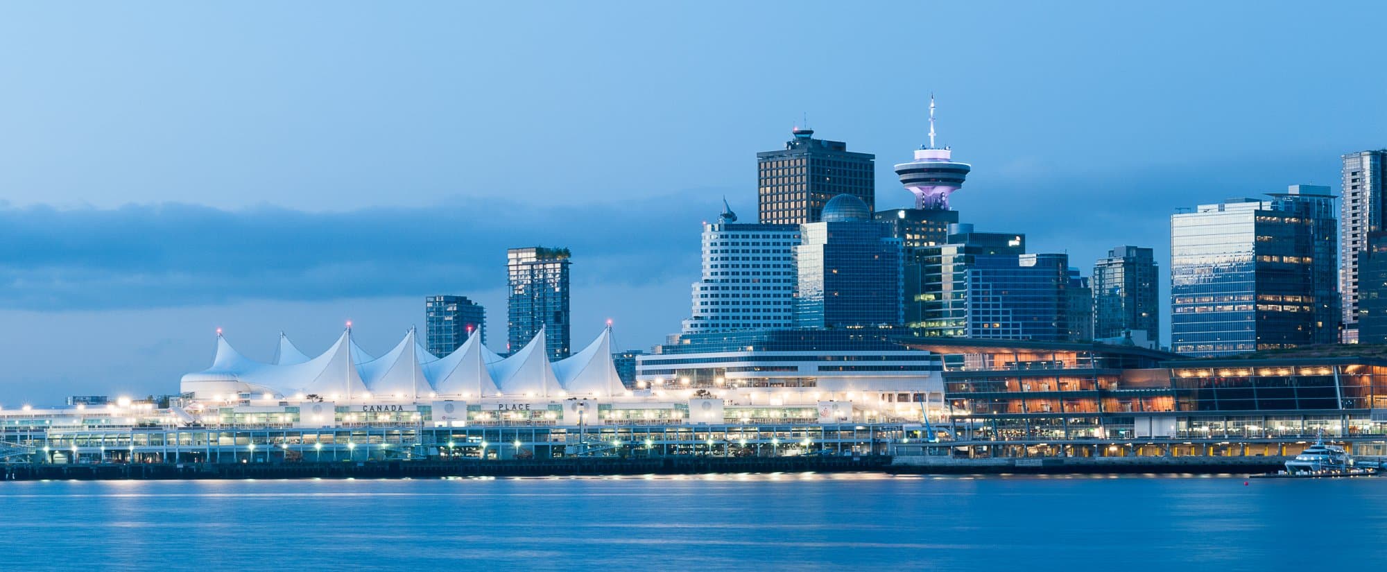 Vancouver Skyline with Canada Place at Dusk A striking twilight view of Vancouver's downtown skyline featuring the iconic white tent-roofed